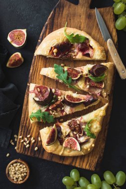 İncir, prosciutto, üzüm, roka ahşap hizmet yönetim kurulu ile gözleme. Üstten görünüm. Lezzetli pizza