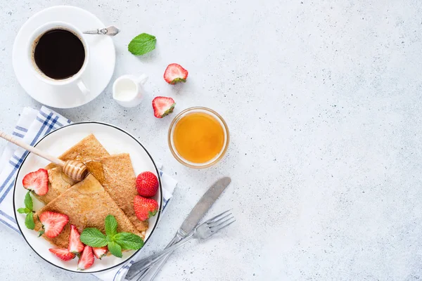 Французькі крепи з полуницю, мед і чашкою кави на стіл — стокове фото