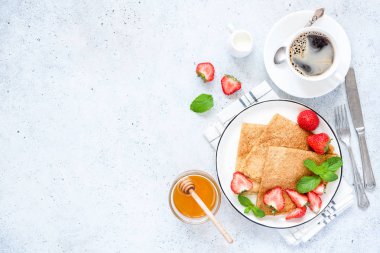 Krep veya Rus Blini Fransız taze çilek, tatlım, beton zemin üzerinde kahve. Sağlıklı lezzetli Breakfast. Tablo üstten görünüm, kopya alanı