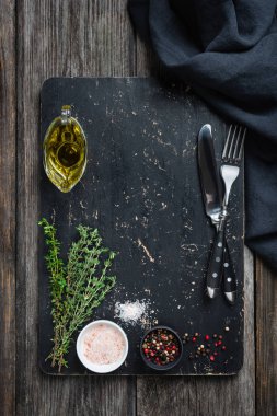 Siyah kesme tahtası, baharat ve çatal bıçak takımı