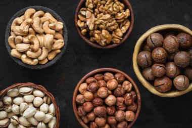 Siyah arka plan üzerine kase içinde çeşitli fındık