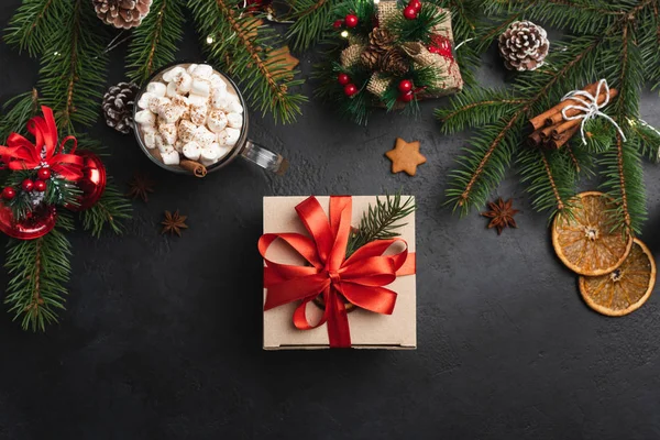 Caja de regalo sobre fondo de hormigón negro y decoraciones navideñas — Foto de Stock