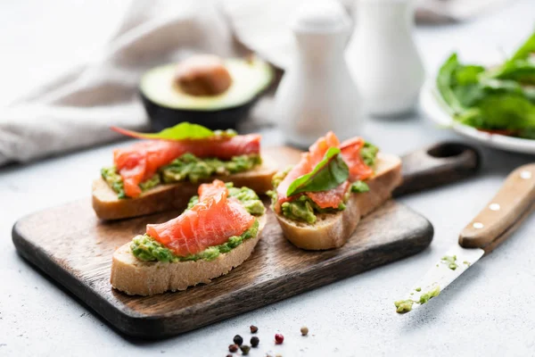 Tostadas de salmón con aguacate. Snack o aperitivo saludable — Foto de Stock