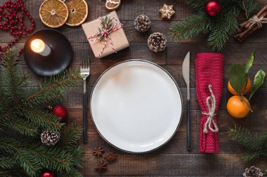 Otantik Noel masa ayarı. Boş tabak, mumlar, gümüş eşyalar, çam ağacı, hediye kutuları. Metin kopyalama yeri olan üstten görünüm
