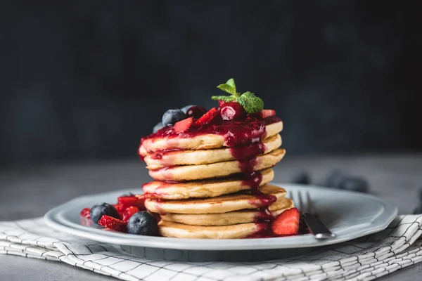 Pancakes with berry sauce and berries