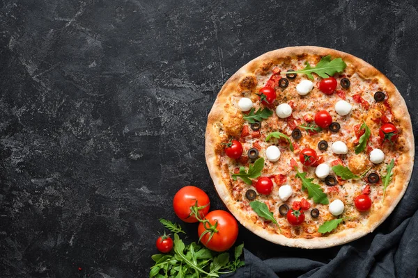 Chutná pizza s rajčaty a mozzarellou na černém pozadí — Stock fotografie