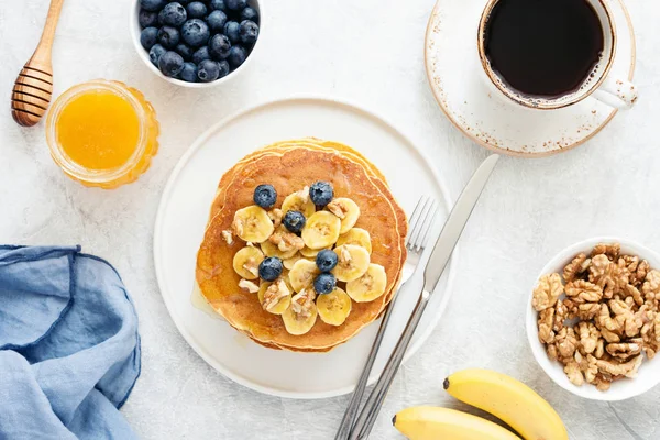 Clătite cu banane, afine și ceașcă de cafea, mic dejun gustos — Fotografie, imagine de stoc