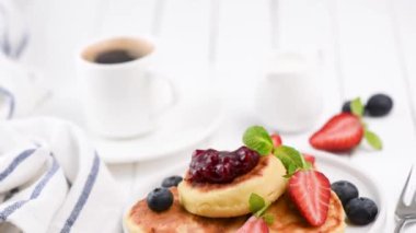 Taze çilek, reçel ve kahve beyaz masada Syrniki. Sağlıklı lezzetli breakfast