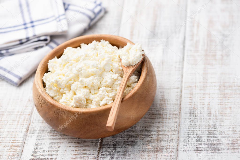 Cottage cheese, farmers cheese in wooden bowl