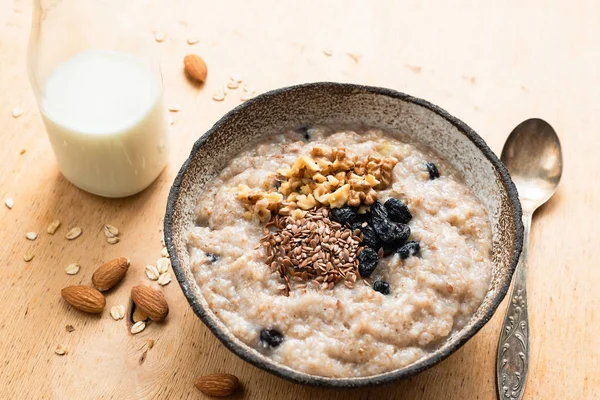 Breakfast porridge oats in bowl on wooden table — Stock Photo, Image