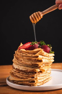 Blini üzerinde bal dökme, krepler
