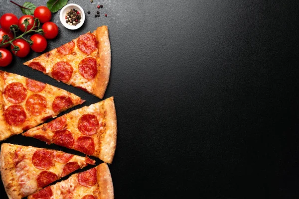 Pepperoni pizza skivor på svart bakgrund — Stockfoto