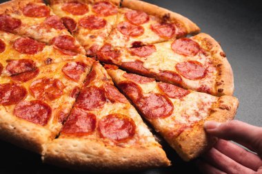 Pepperoni pizza dilimi alarak