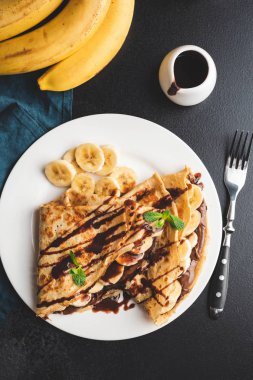 Çikolata yaymak ve muz ile krepler