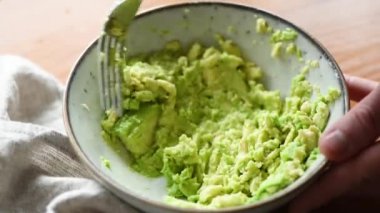 Mashing avokado büyük çekim görünümü. Kişi kasede avokado sosu guacamole hazırlar. HD görüntüleri