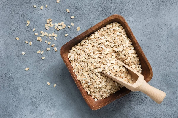 Copos de avena, avena enrollada en cuenco de madera con cuchara —  Fotos de Stock