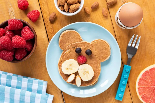 Барвистий сніданок для дітей, смішний млинець, яйце та фрукти — стокове фото