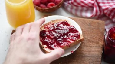 Reçel ile kahvaltı tost yemek. Kişi fıstık ezmesi ve jöle tost ısırık alıyor. HD görüntüleri