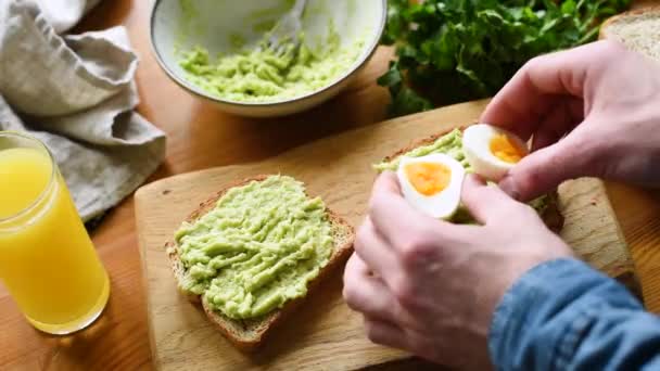 Rostat Bröd Med Mosad Avokado Och Kokt Ägg Man Förbereder — Stockvideo