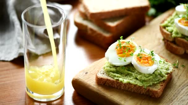 Sok Pomarańczowy Nalewanie Szkła Toast Jajkiem Awokado Boku Zdrowe Śniadanie — Wideo stockowe