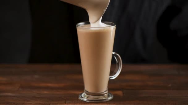 バリスタは 蒸したミルクフォームやホイップクリームをスローモーションでコーヒーに追加します — ストック動画