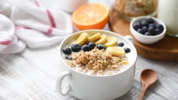 Granola Con Leche Frutas Frescas Tazón Sobre Mesa Madera Blanca — Vídeo de stock