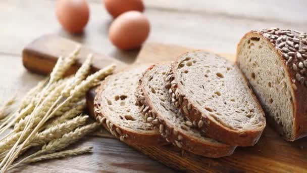 木製のまな板の上の種でスライス全体の穀物のパン ヒマワリの種とサワードウブレッドのクローズビュー — ストック動画