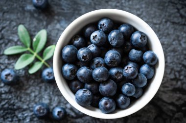 Siyah arka planda kase taze yaban mersini