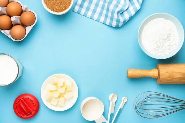 Bakgerei en ingrediënten op blauwe achtergrond — Stockfoto