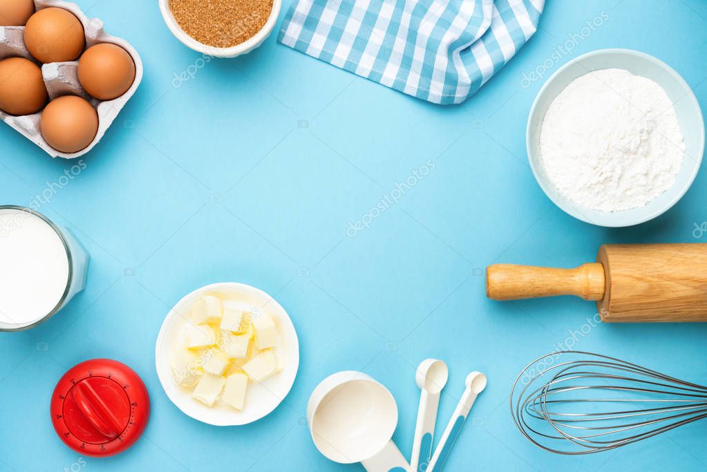 Baking utensils and ingredients on blue background