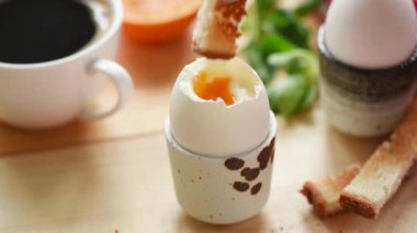 Yavaş çekimde yumurta sarısı içine tost ekmek daldırma. Yumuşak haşlanmış yumurta yemek. Lezzetli kahvaltı, yakın çekim görünümü