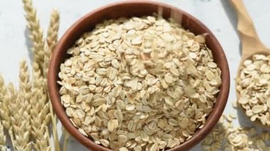 Yuvarlanmış yulaf veya yulaf gevreği kaseye düşen yavaş hareket. Sağlıklı gıda, temiz beslenme, sağlıklı yaşam tarzı kavramı