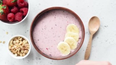 Vegan acai smoothie kase üst görünümü meyve ve granola ile tepesinde. Kadın superfood smoothie kase yapma.