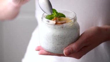 Kavanozdan chia pudingi yiyen kişi. Yakın çekim görünümü. Sağlıklı beslenme, sağlıklı yaşam tarzı kavramı