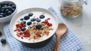 Yogurt with granola and berries in a bowl, healthy breakfast food