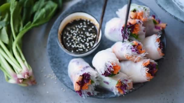 Eating Spring Roll Asian Cuisine. Person picking rice paper roll with chopsticks and dipping it into sesame teriyaki sauce. Asian food culture — Stock Footage Eating Spring Roll Asian Cuisine Person Picking Rice Paper Roll Video Clip