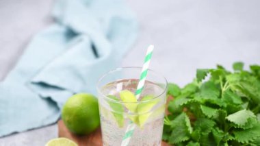 Kireç ve nane veya limonlu soda ile köpüklü yaz kokteyli. İçme kokteyl tüpü ile cam buz gibi ferahlatıcı yaz içkisi