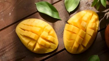 Mango üst görünümü yarıya ve ahşap masa üzerinde küpler halinde kesilmiş