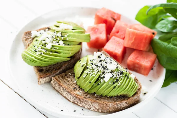 Aguacate en rodajas con queso blanco suave en tostadas — Foto de Stock