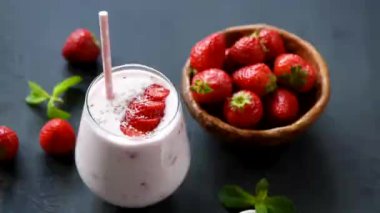 Siyah masa üzerinde cam sağlıklı çilek smoothie. Protein Milkshake
