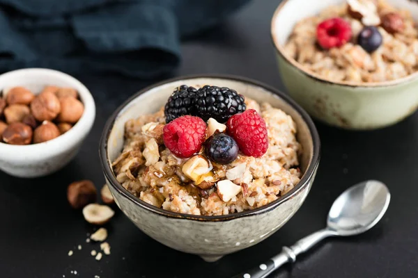 Oatmeal porridge with berries, nuts and honey — Stock Photo, Image