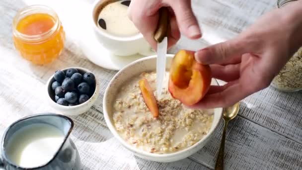 Giovane Donna Mani Affettare Pesca Nella Ciotola Porridge Farina Avena — Video Stock