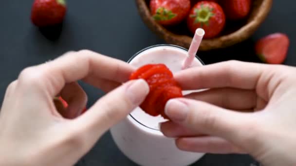 新鮮なイチゴでミルクセーキやスムージーを飾る女性 健康的な食べ物と飲み物のコンセプト — ストック動画