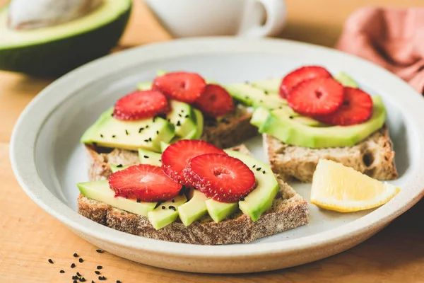 Rye toast with avocado and strawberry — Stock Photo, Image