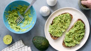 Püre avokado, kişniş ve kabak çekirdeği ile tost. Adamın elleri tohumlarla sağlıklı vegan kahvaltı süsler. Yağ asitleri, omega-3 ve protein lisyonu açısından zengin