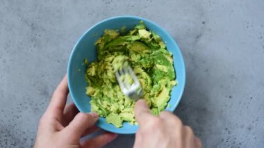 Guacamole sosu yapmak için kasede avokado püresi ellerin Closeup görünümü