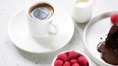 Çikolata lav kek veya fondan taze ahududu ve siyah kahve fincan ile servis