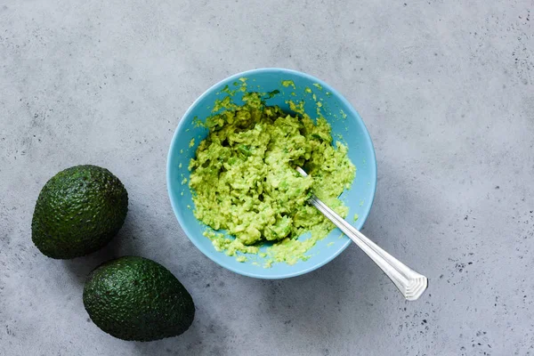Mashed avocado in bowl table top view — Stock Photo, Image