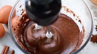 Mikser ile bir kapta çikolatalı kek veya kurabiye hamuru hazırlanıyor. Yakın çekim görünümü. Pişirme, pişirme süreci, mutfak ekipmanları