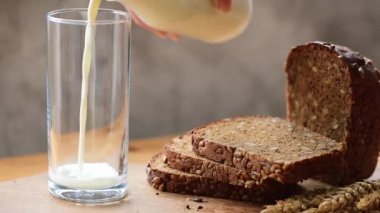 Bir bardağa sütü döküyor. Sağlıklı süt ürünleri, organik çiftlik gıda